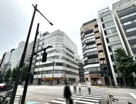出入口近くの横断歩道で反対側に渡り、スギ薬局に面した道を直進すれば当ビル着